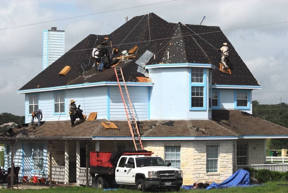 A white truck is parked in front of a house that is being remodeled.