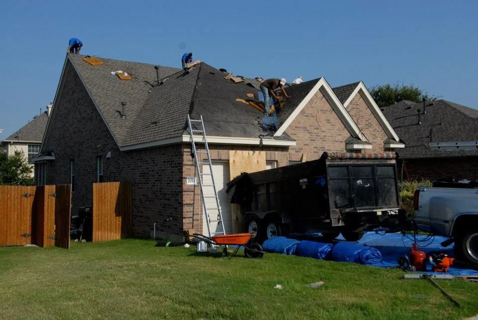 A roofer is working on the roof of a house
