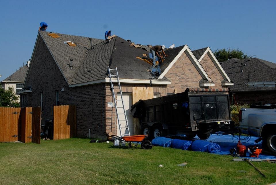 Two men are working on the roof of a house