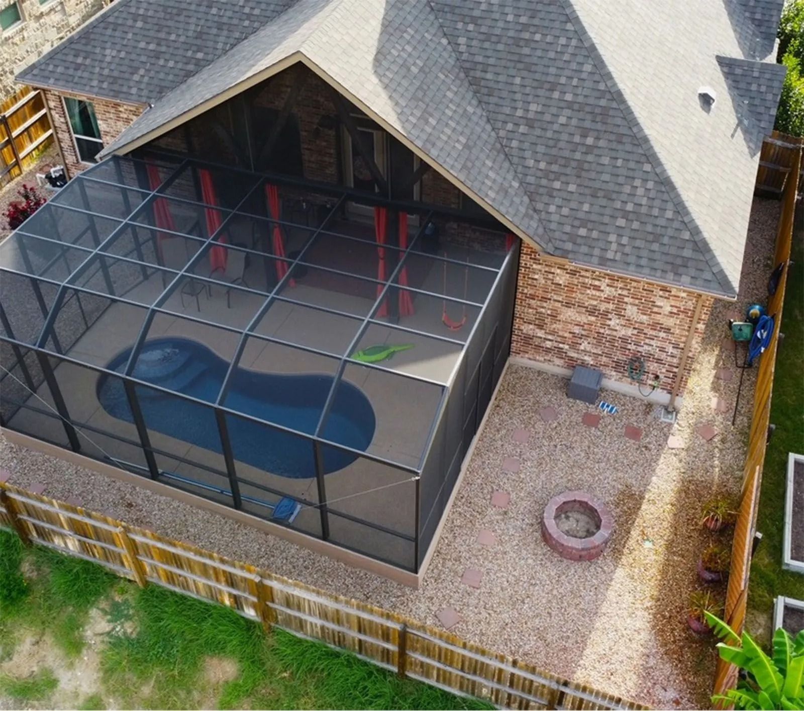 An aerial view of a house with a screened in pool