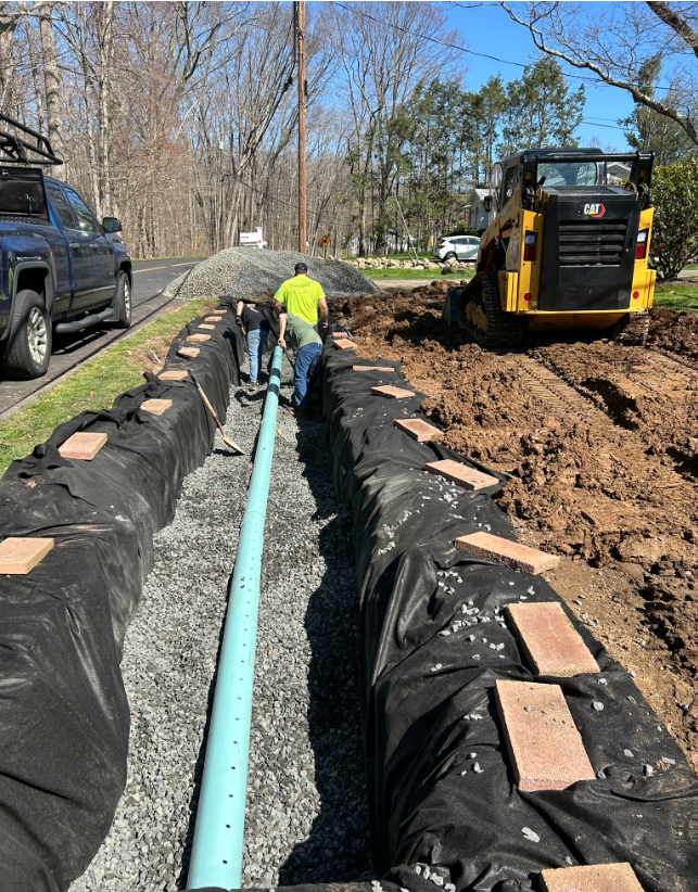 A yellow bulldozer is working on a drainage system