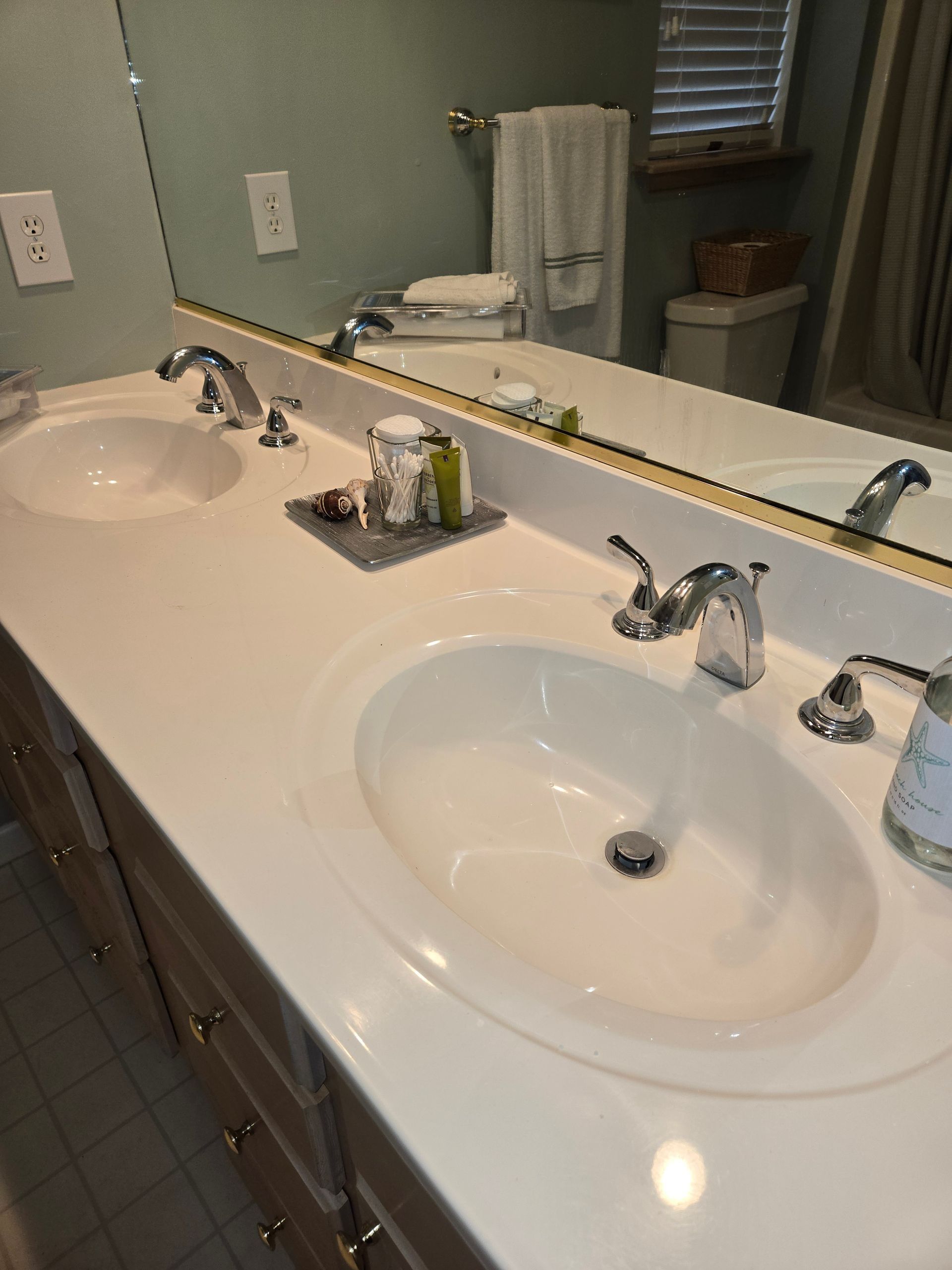 Double bathroom vanity with white countertops, two sinks, and chrome faucets.