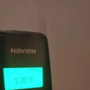 Navien water heater display showing 120°F, on a black panel with a turquoise screen.