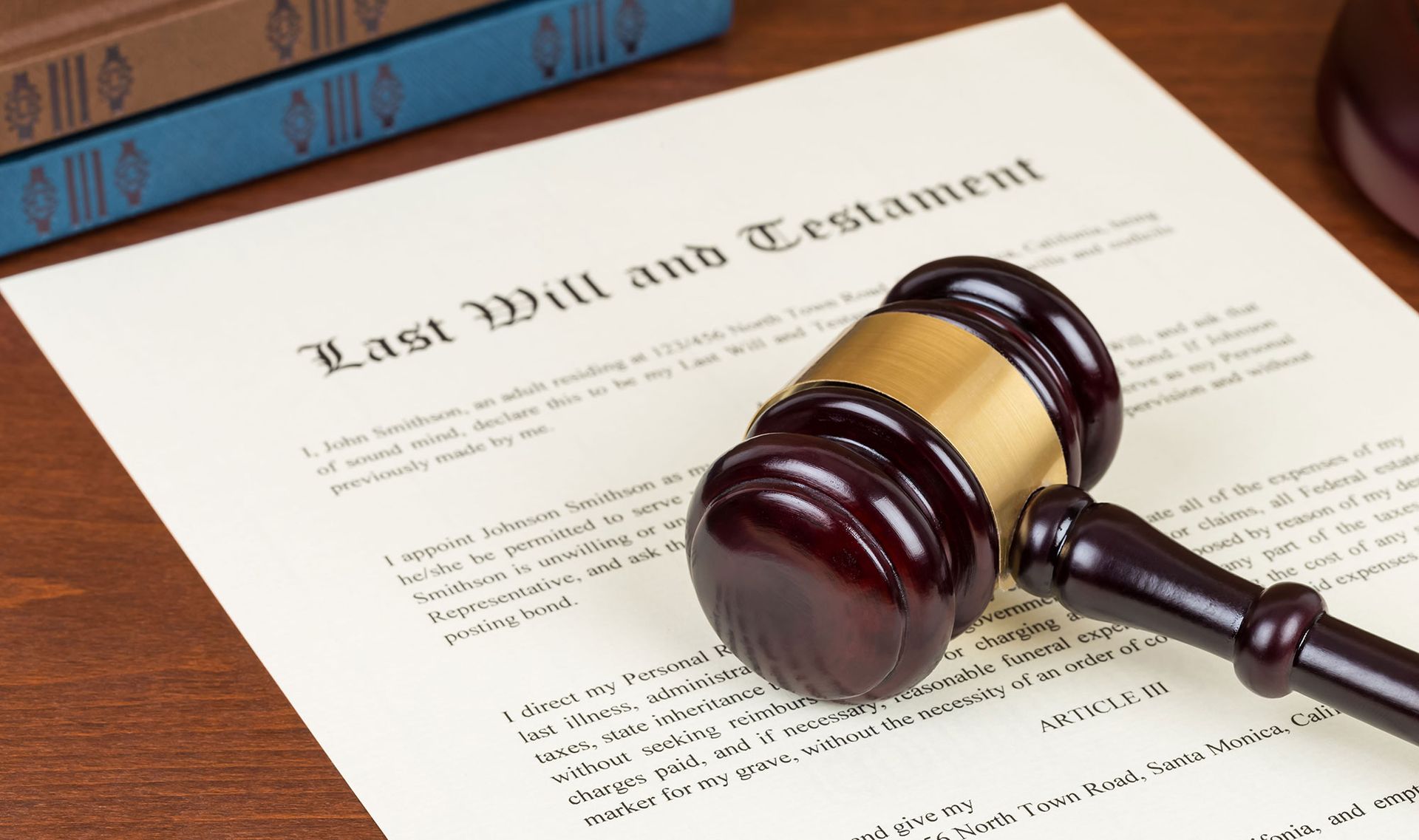 A judge 's gavel is sitting on top of a last will and testament