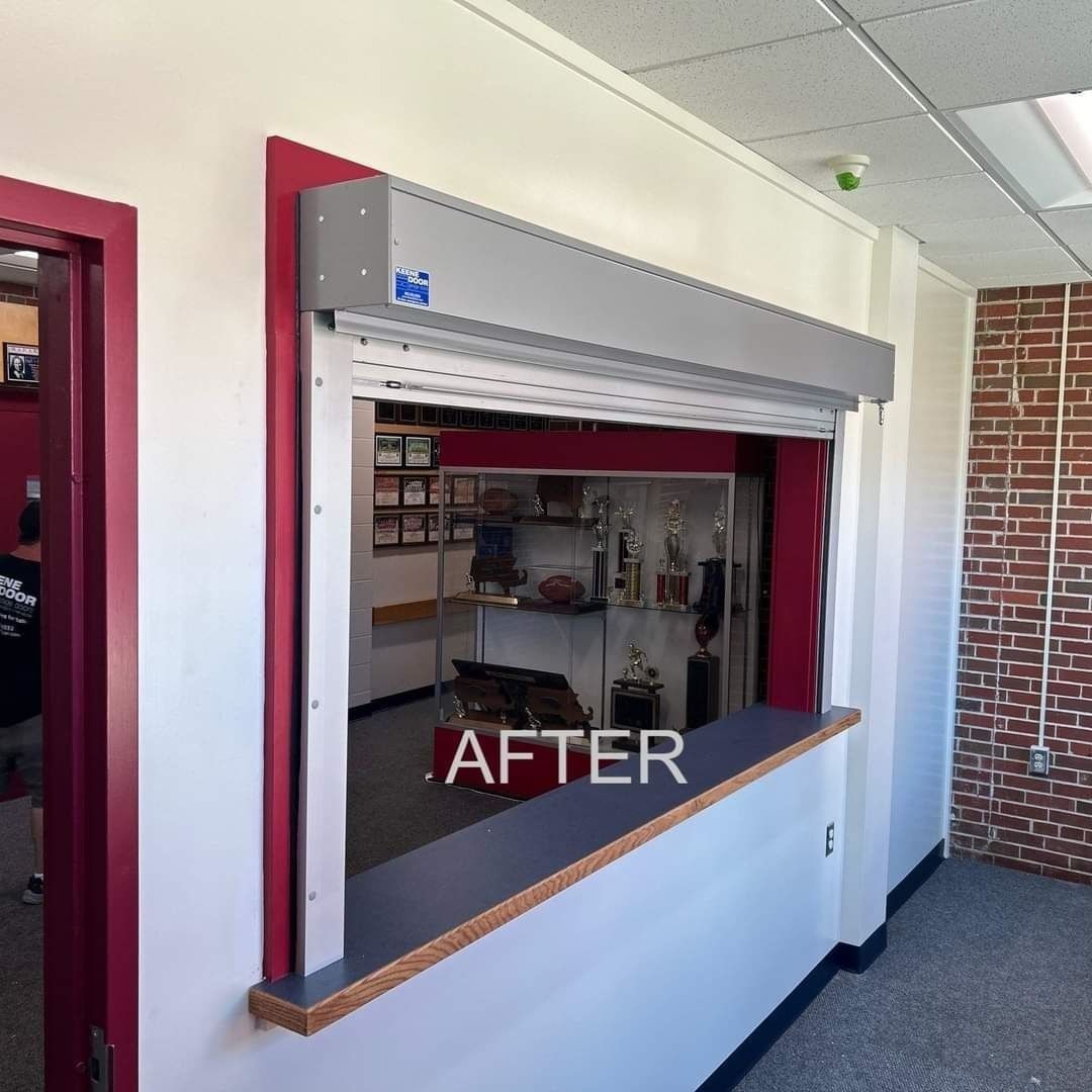 Open service window with gray metal shutter and counter, labeled “AFTER,” inside a white room