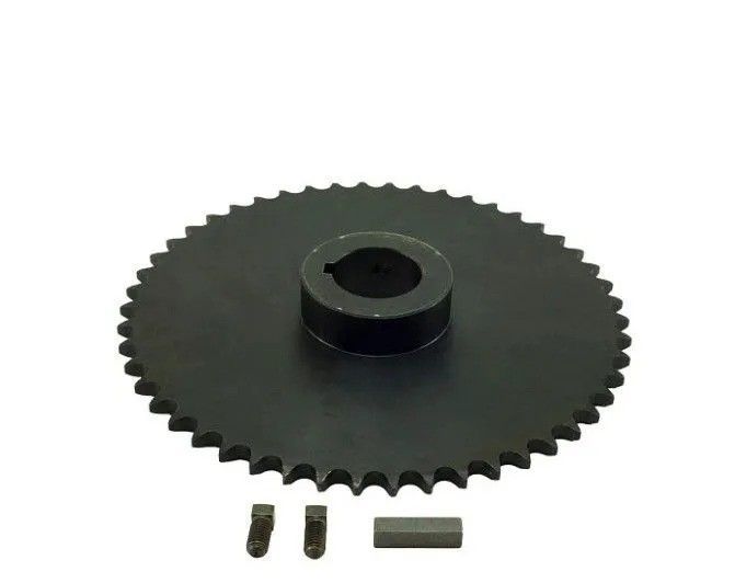 Black toothed gear with a raised hub, shown with two screws and a small rectangular metal piece.