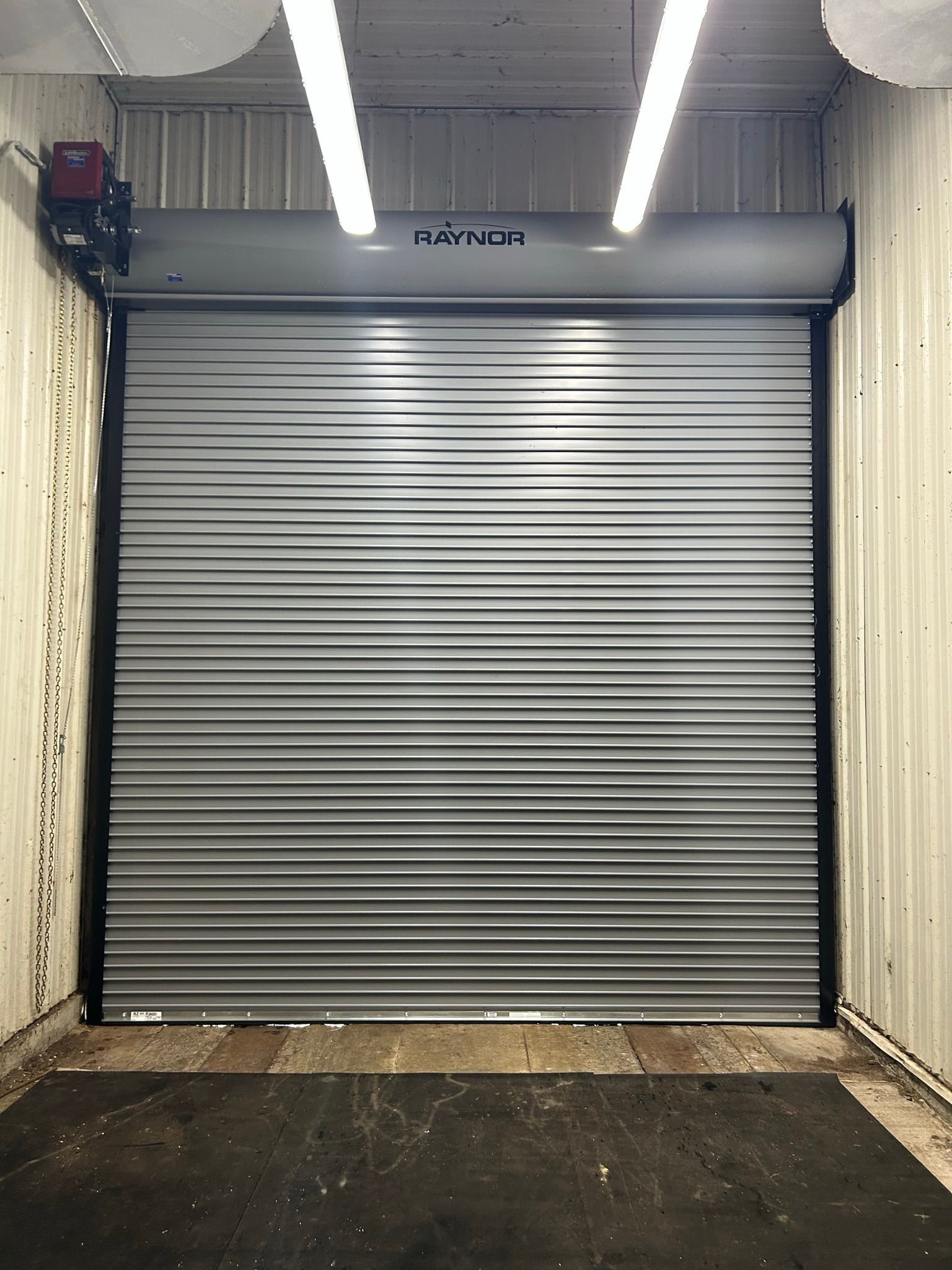 Closed gray roll-up garage door in a concrete loading bay