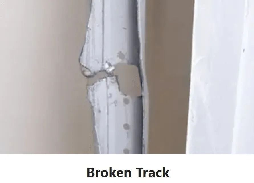 Broken white track with a cracked, bent section near a wall.