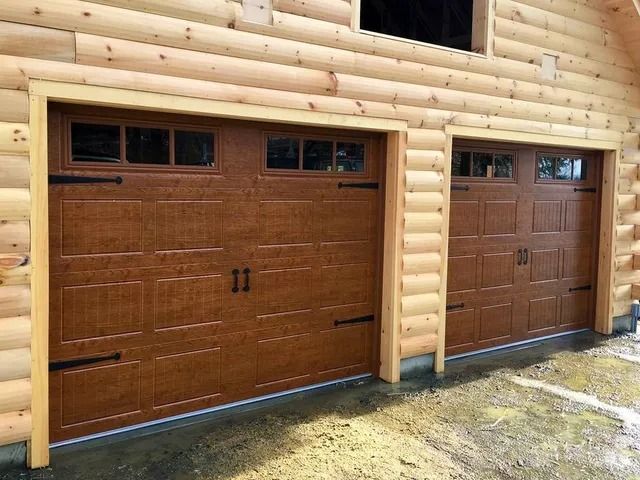 Two brown wooden garage doors on a log cabin exterior