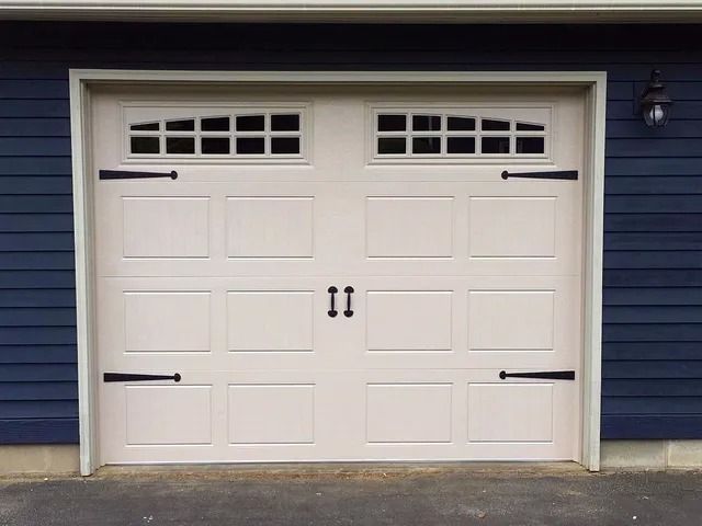 White double garage door on a blue house exterior.