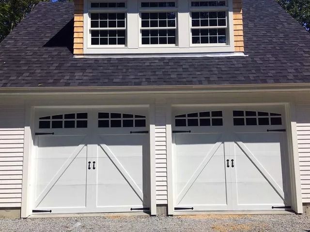 White double garage doors with dormer windows on a house exterior