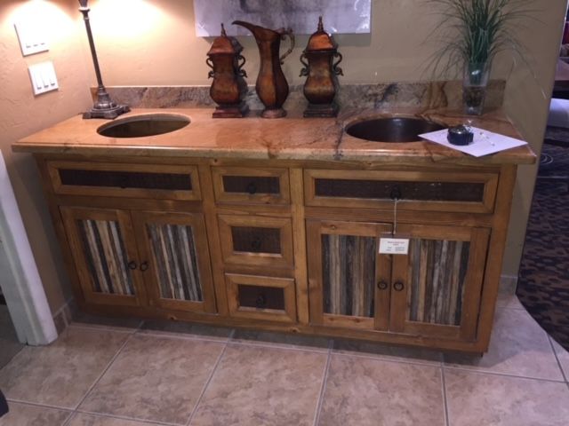 A bathroom vanity with two sinks and cabinets