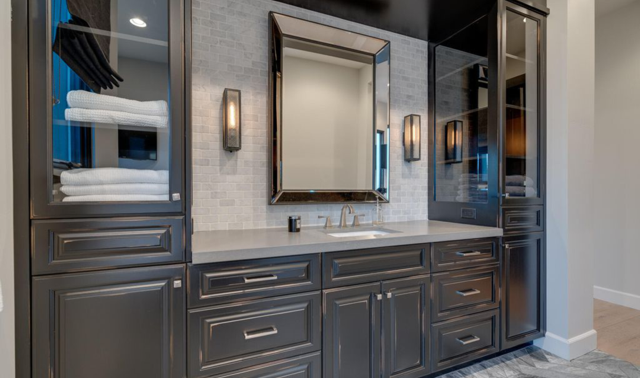 A bathroom with a sink, mirror, and cabinets