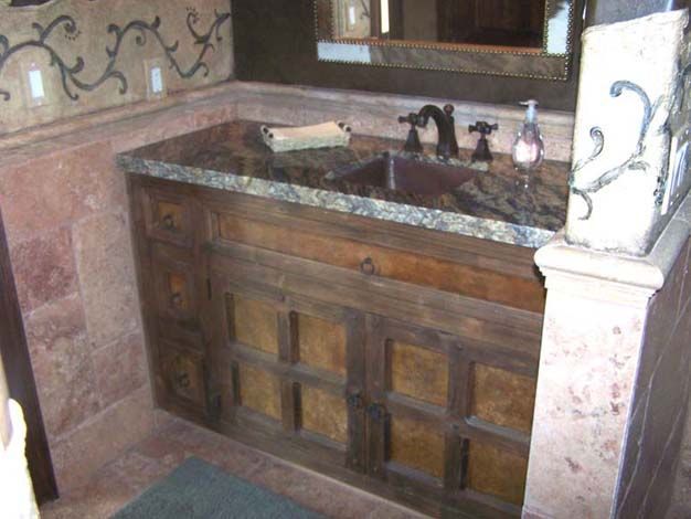 A bathroom with a sink, wooden cabinets, and a mirror