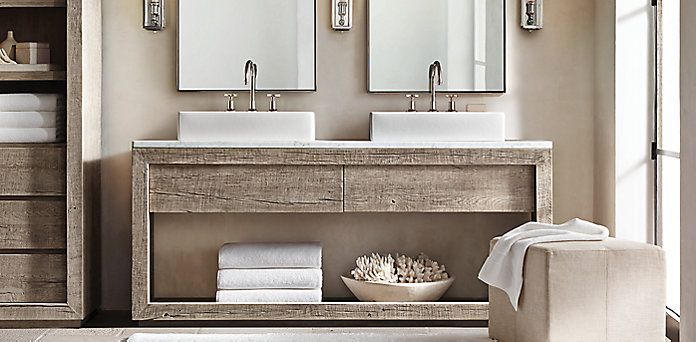 A bathroom with two sinks, cabinets, and two mirrors