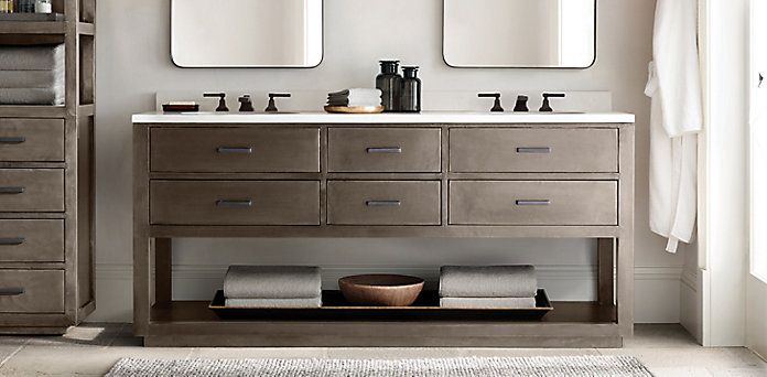 A bathroom with cabinets, two sinks, and two mirrors