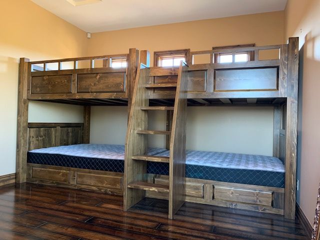 A bedroom with two bunk beds and a ladder