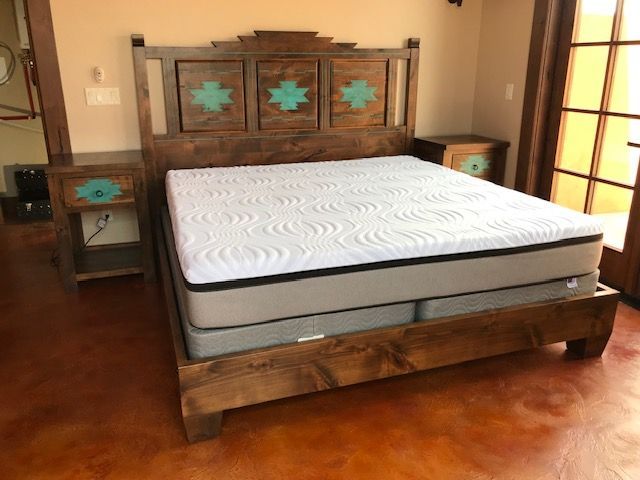 A bed with a mattress and a wooden headboard in a bedroom