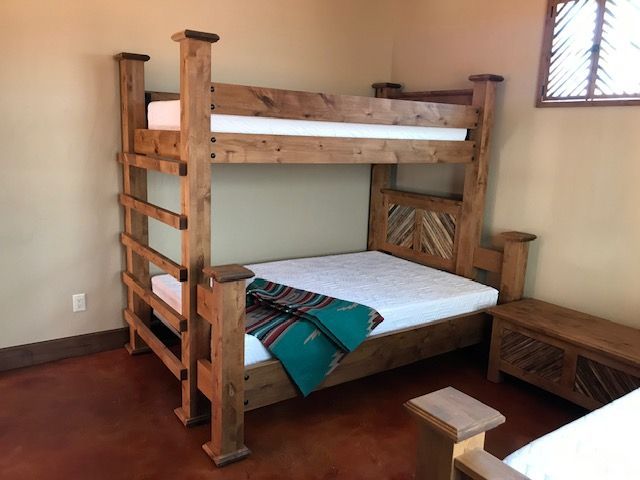 A bunk bed with a green blanket on it in a room
