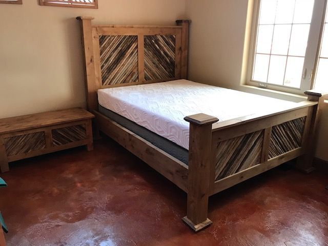 A bedroom with a wooden bed and a mattress