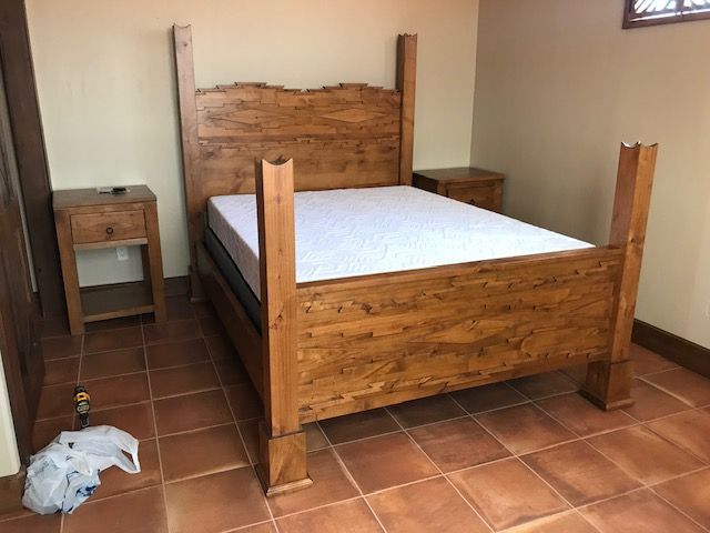 A wooden bed with a white mattress and two nightstands in a bedroom