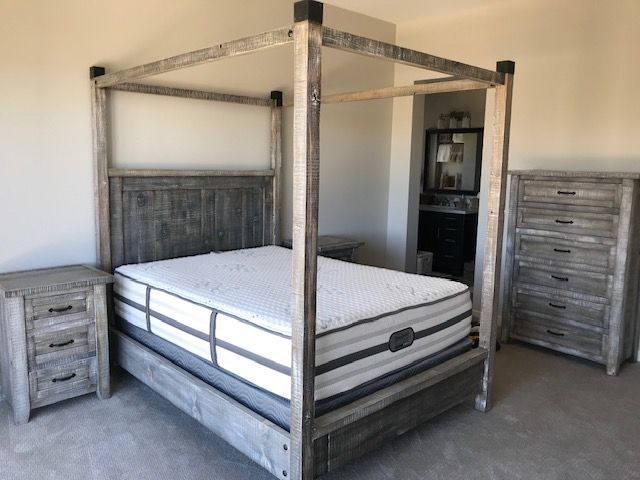 A bedroom with a canopy bed and a mattress