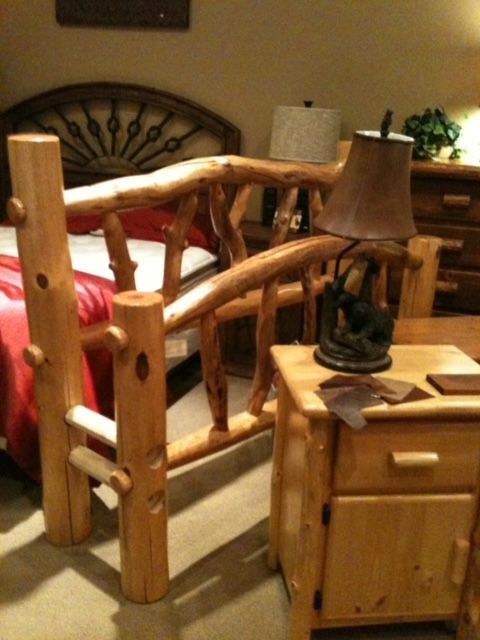 A bedroom with a bed a nightstand and a lamp