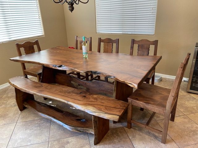 A wooden table with a bench and chairs in a dining room