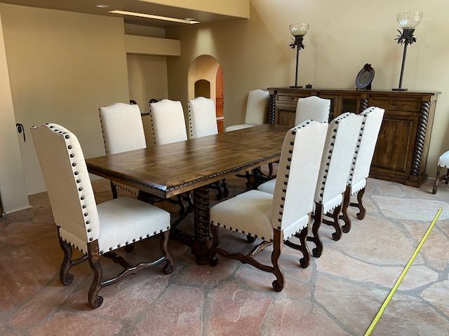 A dining room with a wooden table and white chairs