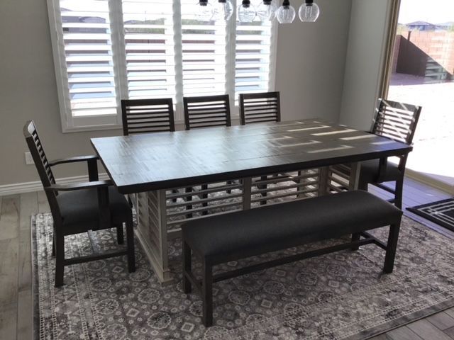 A dining room table with chairs and a bench