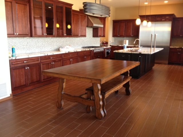 A kitchen with stainless steel appliances, wooden cabinets, and a dining table