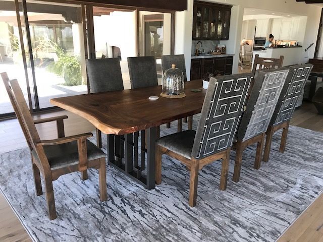 A dining room with a wooden table and chairs