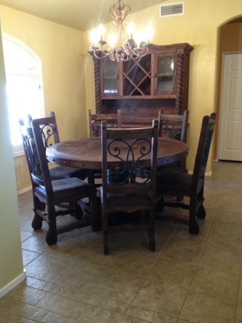 A dining room with a round table and chairs