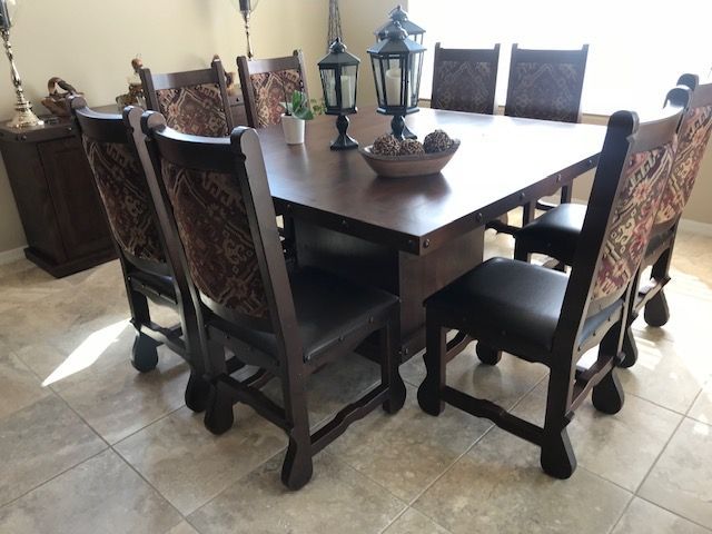 A dining room table with chairs and lanterns on it