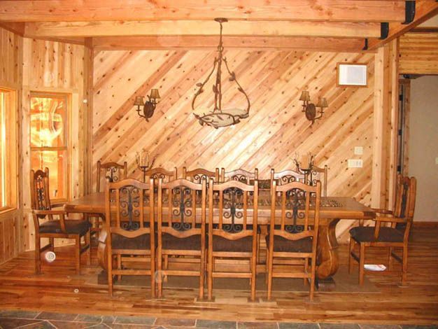 A dining room with a wooden table and chairs
