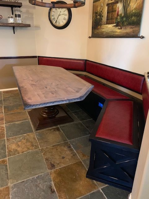 A room with a dining table and a clock on the wall