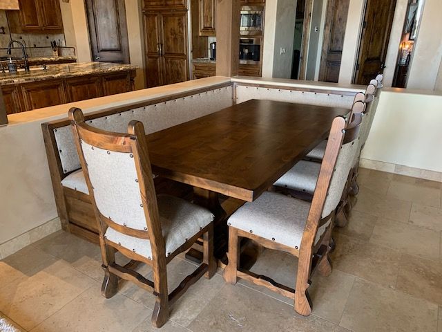 A kitchen with a dining table and chairs in it