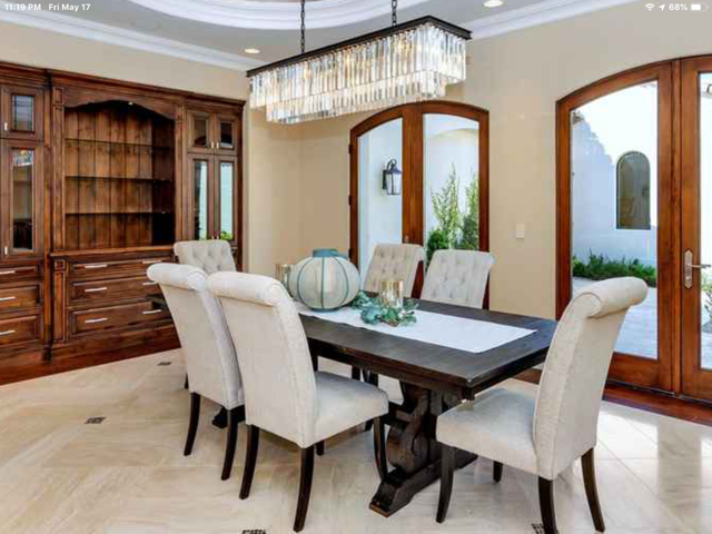 A dining room with a table and chairs and a chandelier