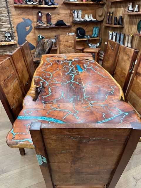 A wooden dining table and chairs in a room with a collection of cowboy boots displayed on the shelves