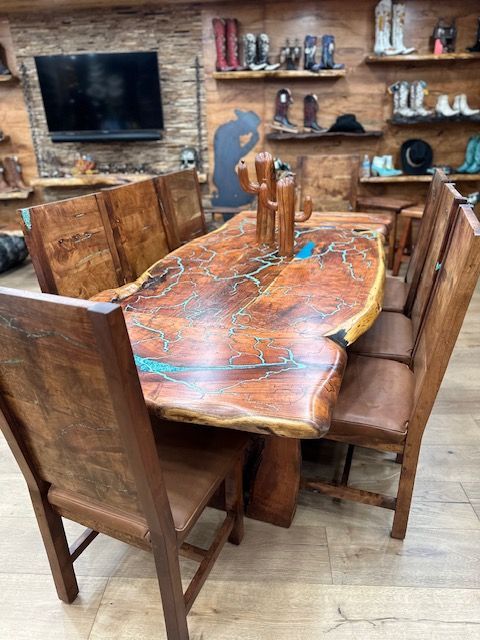 A wooden dining table and chairs in a room with a collection of cowboy boots displayed on the shelves