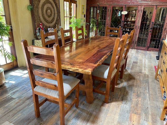 A long wooden dining table with chairs in a room
