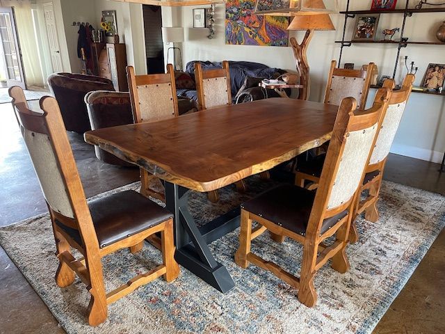 A wooden dining table and chairs are sitting on a rug in a living room