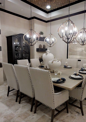 A dining room with a table and chairs and a chandelier hanging from the ceiling