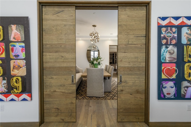 A room with sliding wooden doors and paintings on the wall