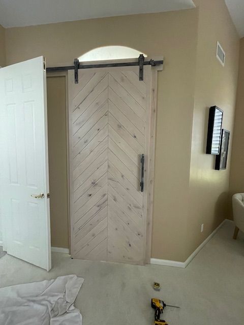A sliding barn door is being installed in a bathroom