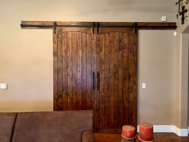 A living room with a couch and two candles in front of a sliding barn door