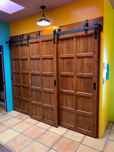 A row of wooden sliding barn doors in a room