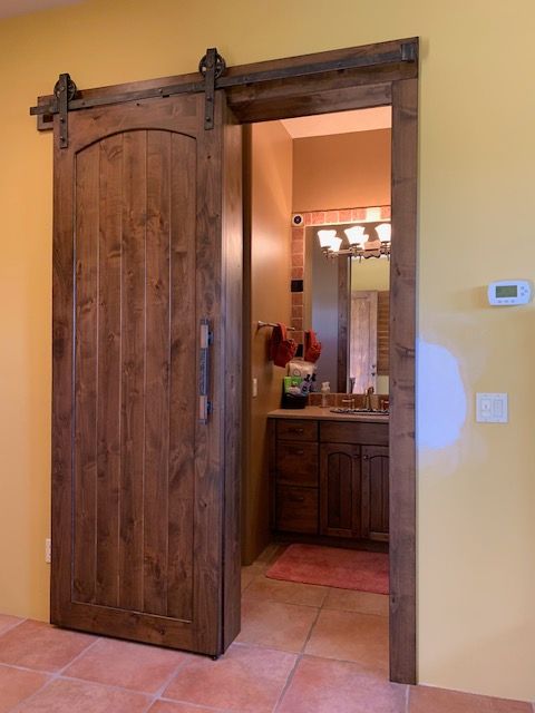 A bathroom with a sliding barn door leading to it