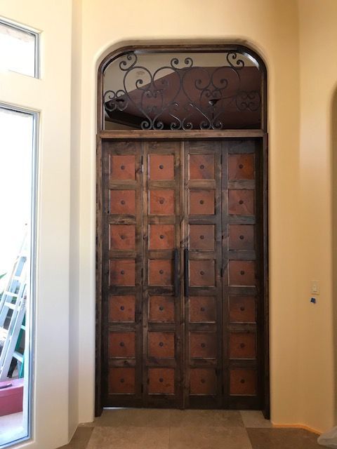 A large wooden door with squares on it is in a hallway