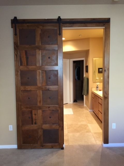 A sliding barn door opens to a bathroom